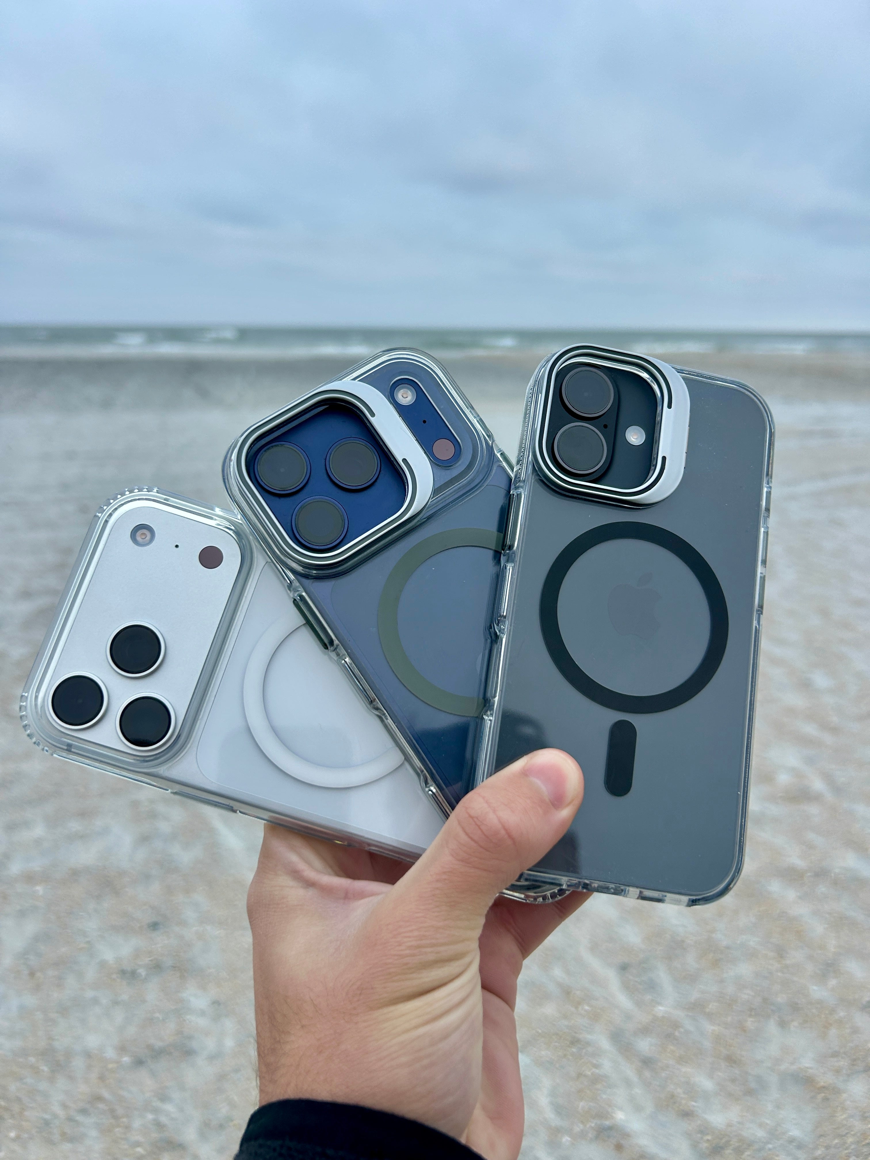 Four phone case designs held by a hand with a beach background